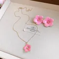 Vista detallada de un elegante conjunto de joyas con flores de esmalte rosado - Conjunto de 2 piezas Collar Pendientes / Rosa