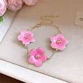 Elegant pink enamel flower bracelet featuring three charms and an adjustable gold chain - Bracelet / Pink