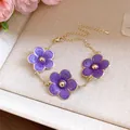 Exquisita pulsera con dijes de flores moradas y cadena dorada ajustable muy elegante - Pulsera / Púrpura