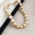 Nahaufnahme der Sommerperlenkette mit cremefarbenen Marmorperlen und Gold-Abstandshalter - Khaki