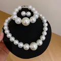 Dettaglio del set di gioielli con perle bianche su un espositore professionale nero - Collana Braccialetto Orecchini (Set da 3 Pezzi) / Bianco perla