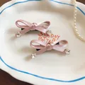 Detail van zoete roze satijnen strik haarspelden met stervormige kristalaccenten - Eendenbek haarclips / Roze