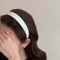 Primer plano de una diadema blanca ancha decorada con diamantes de imitación de colores - Blanco