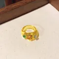 Close-up detail of a yellow resin ring featuring colorful inlaid rhinestones in a tray. - Yellow-Coffee