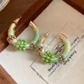 Primer plano de pendientes étnicos en forma de C con cuentas verdes y hilo - Estilo Tejido en C (HE34892) / Dorado-Verde