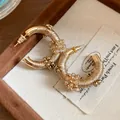 Detalle macro de pendientes étnicos en C con hilo de seda y cuentas de cristal - Estilo Tejido en C (HE34892) / Dorado-Marrón
