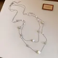 Detalle de un collar francés de dos capas con perlas blancas y cuentas plateadas brillantes. - Plateado