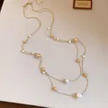 Detalle del collar francés de doble capa con perlas elegantes y cuentas doradas - Dorado