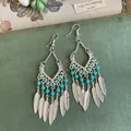 Detailansicht von Vintage-Boho-Ohrringen mit türkisfarbenen Perlen und Metallfedern. - Silber Blauer Ohrhaken
