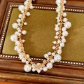 Gedetailleerde close-up van een vintage ketting in paleisstijl met witte parels - Ketting / Goud-Wit