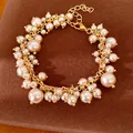 Elegant armband in paleisstijl met parelfranjes, goudkleurige afwerking en verstelbare ketting. - Armband / Goud-Bruin