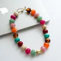 Primo piano di una collana retrò con perle di acrilico marmorizzate su uno sfondo laptop - Colorato