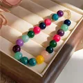 Close-up of vibrant multi-colored acrylic beaded necklace in a luxury wooden display box - Colorful