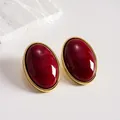 Detailed view of vintage marbled red acrylic oval stud earrings with gold frame - Red