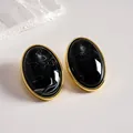 Vintage black marbled acrylic oval stud earrings set in an elegant gold-toned frame - Black