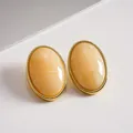 Vintage geometric oval stud earrings featuring cream marbled acrylic centers and golden bezels - Cream