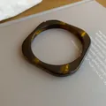 Close-up of a vintage tortoiseshell resin bangle with a square shape on a grey surface - Geometric Bangle Style (47#)