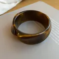 Close-up of vintage twisted dark amber resin bangle on a minimalist book background. - Irregular Faceted Style (54#)