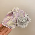 Dettaglio di una molletta per capelli etnica con frange argentate e fiocco a fantasia. - 25# Pinza Fiocco Floreale Lurex Viola / Giallo E Viola