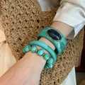 Dettaglio di set di braccialetti in acrilico verde acqua con texture marmorizzata. - Stile 57 / Ciano
