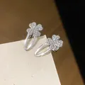 Vue détaillée de barrettes trèfle incrustées de strass étincelants sur carte texturée. - Style Trèfle (HH9935) / Pièce Unique / Argent