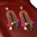 Detailed view of rainbow rhinestone tassel earrings with multi-color teardrop gems - Colorful