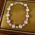 Detalle de una pulsera de circonita floral rosa brillante con un delicado engaste plateado. - Plateado-Rosa