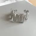 Detailed macro view of silver-tone cuff bracelet with unique hammered geometric texture - Hammered Geometric Style / Silver