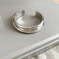 Detail view of a minimalist silver metallic cuff bracelet with elegant layered ribbing. - Smooth Layered Style / Silver