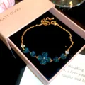 Close-up of 18k gold plated bracelet featuring blue heart-shaped zircons in a clover design. - 2# Bracelet / Gold-Blue