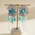 Gedetailleerd overzicht van retro metalen bloemoorbellen met blauwe glazen kralenkwastjes - Zilver-Blauw