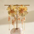 Vintage gouden bloemenoorbellen met kwastjes van perzikglasparels en zilveren studs. - Goudbruin