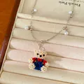 Macro view of a colorful handmade beaded bear necklace pendant with pearl accents - Bear Pendant Necklace / Silver-Multicolor