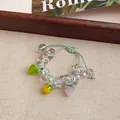 Detail view of handmade summer glass bead bracelet featuring cute apple and grape charms - Style 78 (White, Green, Yellow, and Purple)