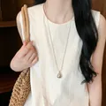 Primo piano dettagliato di una collana con pendente a goccia d'argento su una modella. - Catena Lunga con Goccia Lucida (52#)
