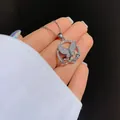 Close-up of butterfly pendant with Love script and zircon stones on a silver chain - Pendant Necklace / White Gold