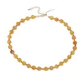 Vue détaillée d'un collier de perles en acrylique ambré avec des accents dorés pour femme. - Jaune