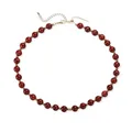 Vue détaillée d'un collier en perles acryliques rouges avec perles d'espacement dorées - Rouge