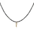 Detailed shot of a gold-plated heart key pendant on a stylish dark beaded necklace - Key Style
