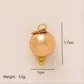 Gros plan d'un pendentif sphérique doré montrant les dimensions 1,7 cm par 1 cm et 3,5 g - Pendentif Boule Dorée / Or