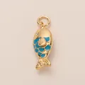 Detailed macro shot of a golden fish charm with blue enamel scales and crystal eye. - Fish Pendant