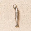 Detailed macro view of a silver stainless steel fish charm pendant with fine scales. - No.2 Long Fish / Silver