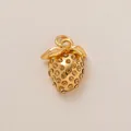 Vista detallada de un amuleto para zapatos de fresa dorado con pedrería ámbar brillante. - Colgante de Fresa