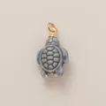 Vista dettagliata di un grazioso ciondolo a tartaruga in ceramica grigia con anello oro - Pendaglio a Tartaruga