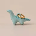 Nahaufnahme eines blauen Keramik-Dinosaurier-Anhängers mit goldenem Ring für DIY - Langhals Dino Anhänger / Hellblau