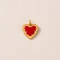 Primo piano di un ciondolo a cuore in smalto rosso con eleganti bordi dorati ondulati. - Toast Cuore (1)