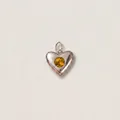 Primo piano di un ciondolo a cuore in acciaio inossidabile con pietra ambrata - Forma di Cuore in Strass Giallo