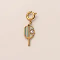 Détail d'un pendentif raquette de pickleball doré avec perle élégante sur fond neutre - Raquette de Tennis