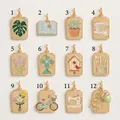 Detail view of 12 gold enamel charms including monstera leaf and succulent designs - Monstera Leaf Pendant (1)