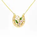 Macro view showing intricate floral enamel and crystal details on gold horseshoe pendant - May Lily of the Valley Horseshoe Necklace